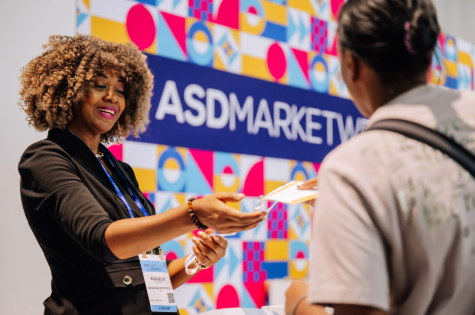 Staff member handing exhibitor badge