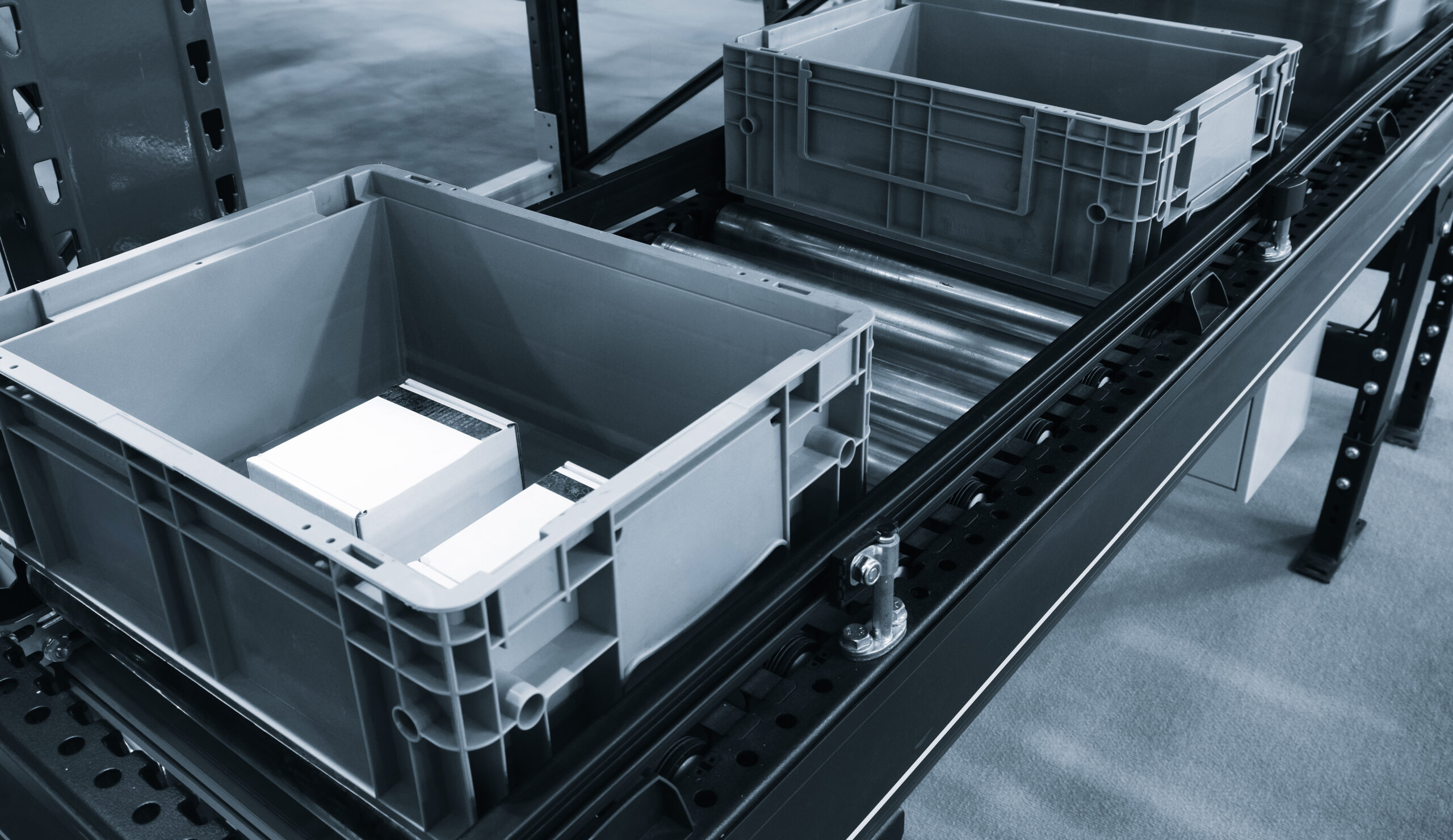 Conveyor belt with two empty plastic containers. Gray containers placed on the conveyor belt.