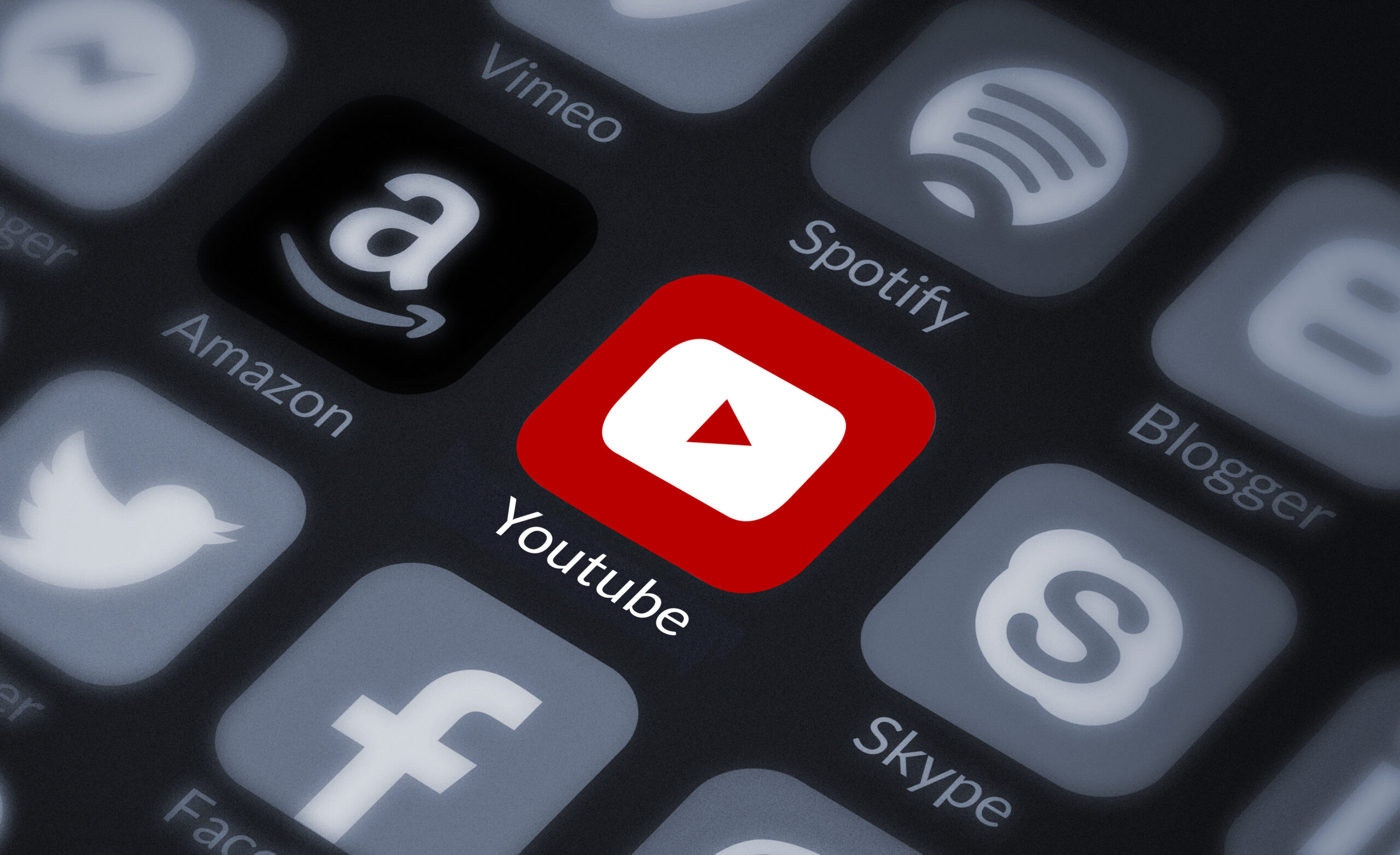 YouTube icon highlighted in red on screen surrounded by other popular app icons.