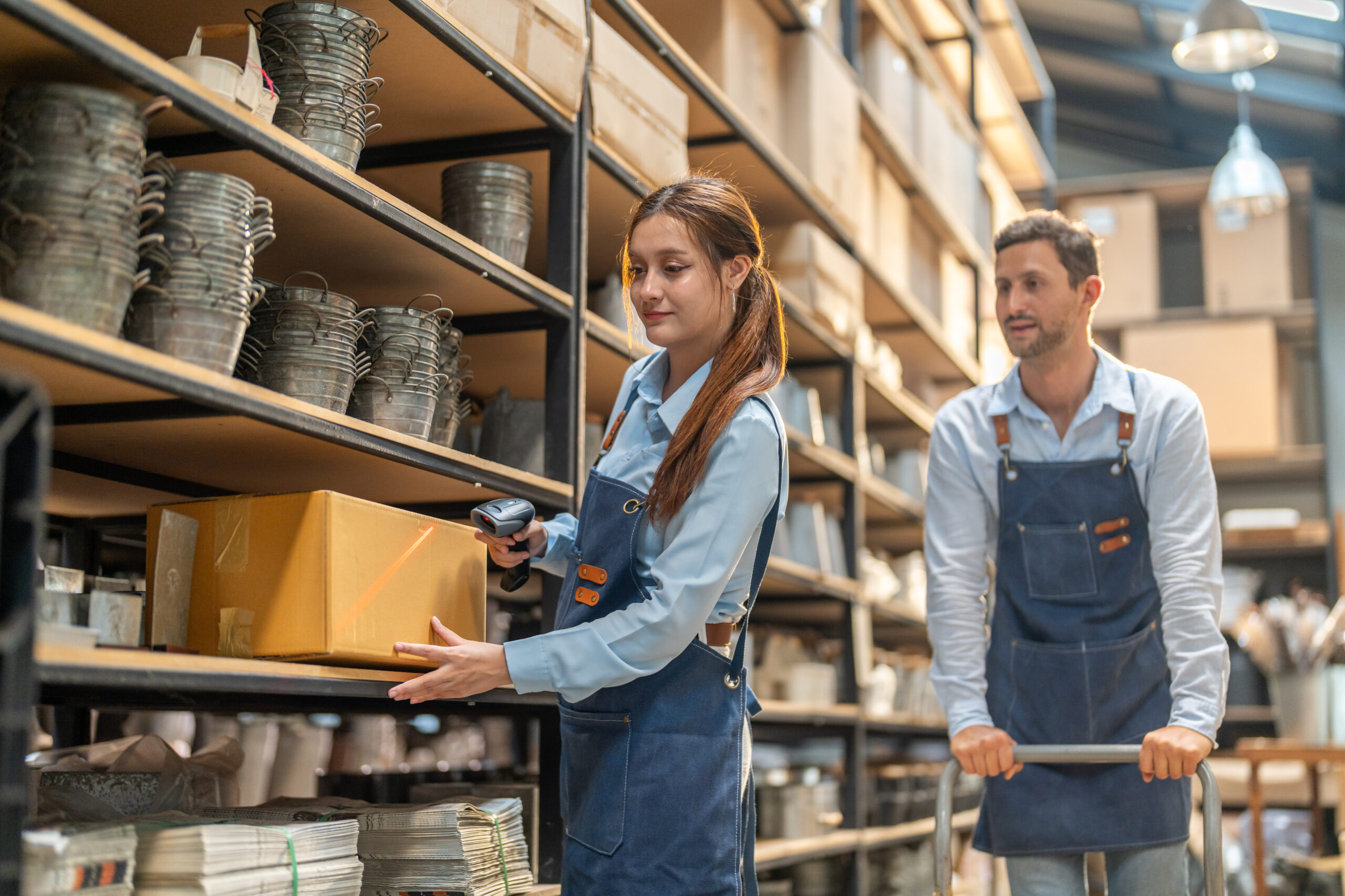 Female warehouse employee using barcode scanner for inventory management