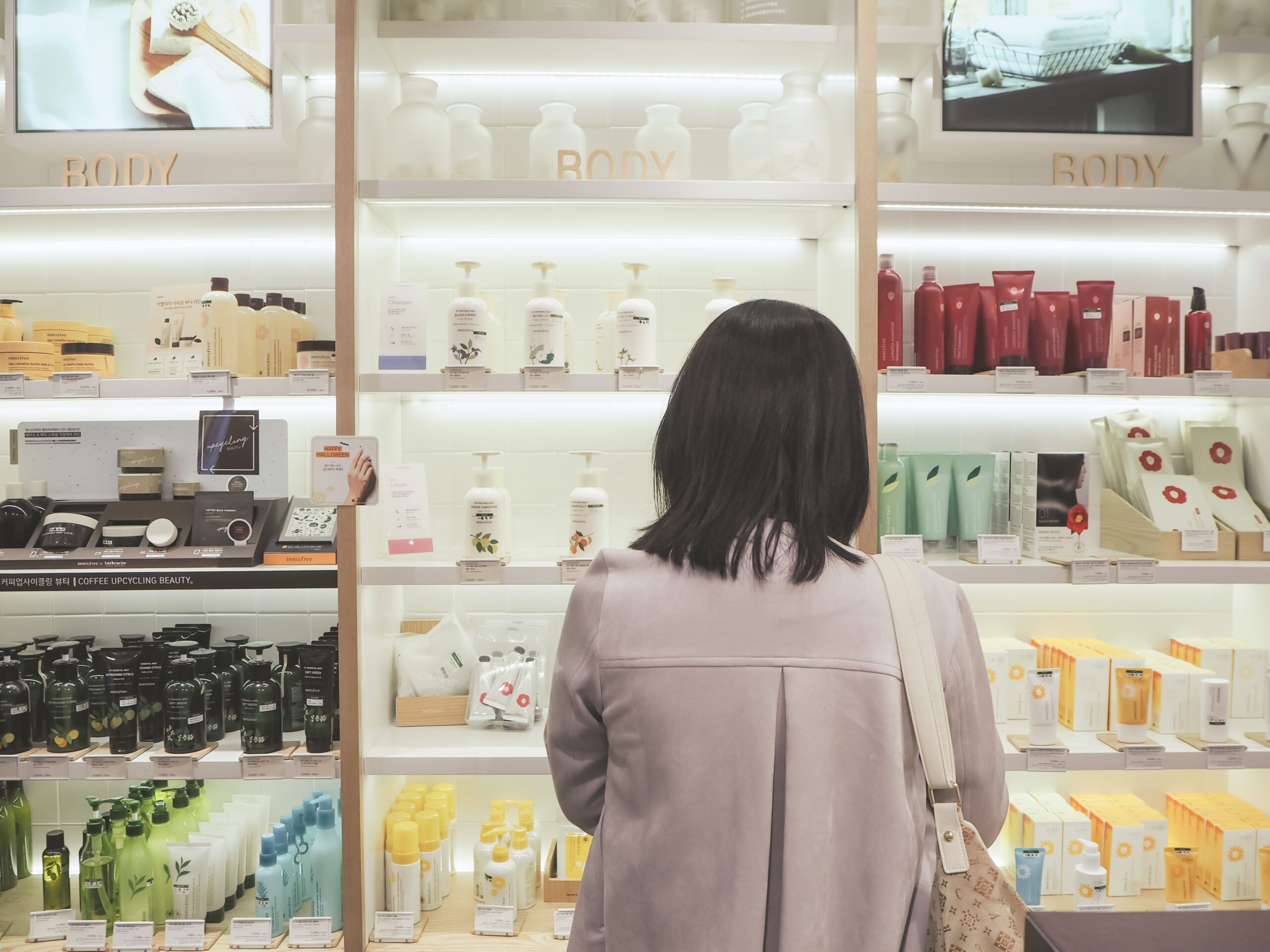 Woman standing in front of a shelf with skincare products of the South Korean brand