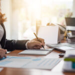 Business woman at working with financial reports and laptop computer in the office