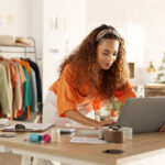 laptop and fashion manager of retail or boutique shop checking clothing stock
