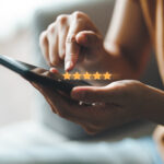 Close up of woman customer giving a five star rating on smartphone.