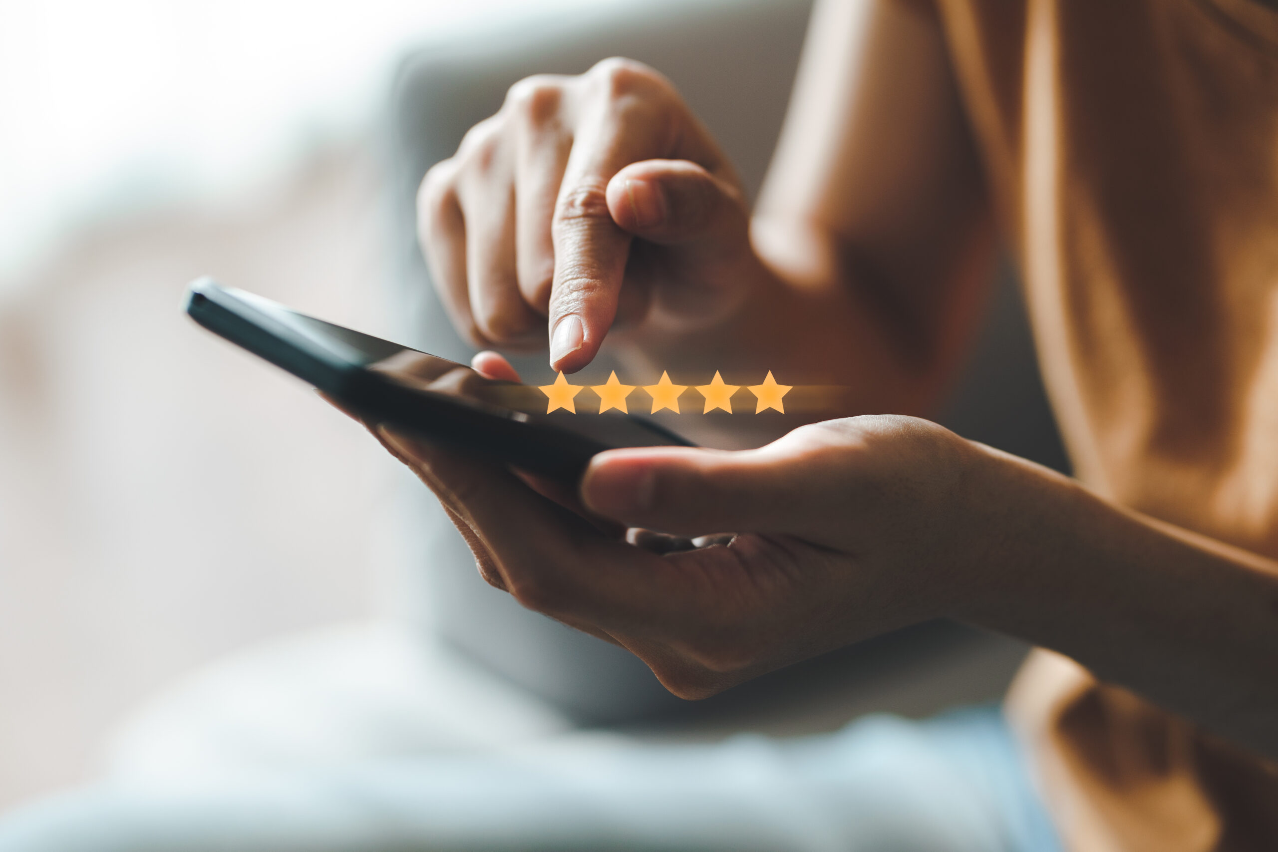 Close up of woman customer giving a five star rating on smartphone.