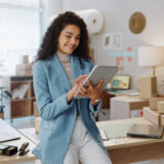 Happy woman, fashion designer and tablet in logistics or small business management at boutique.