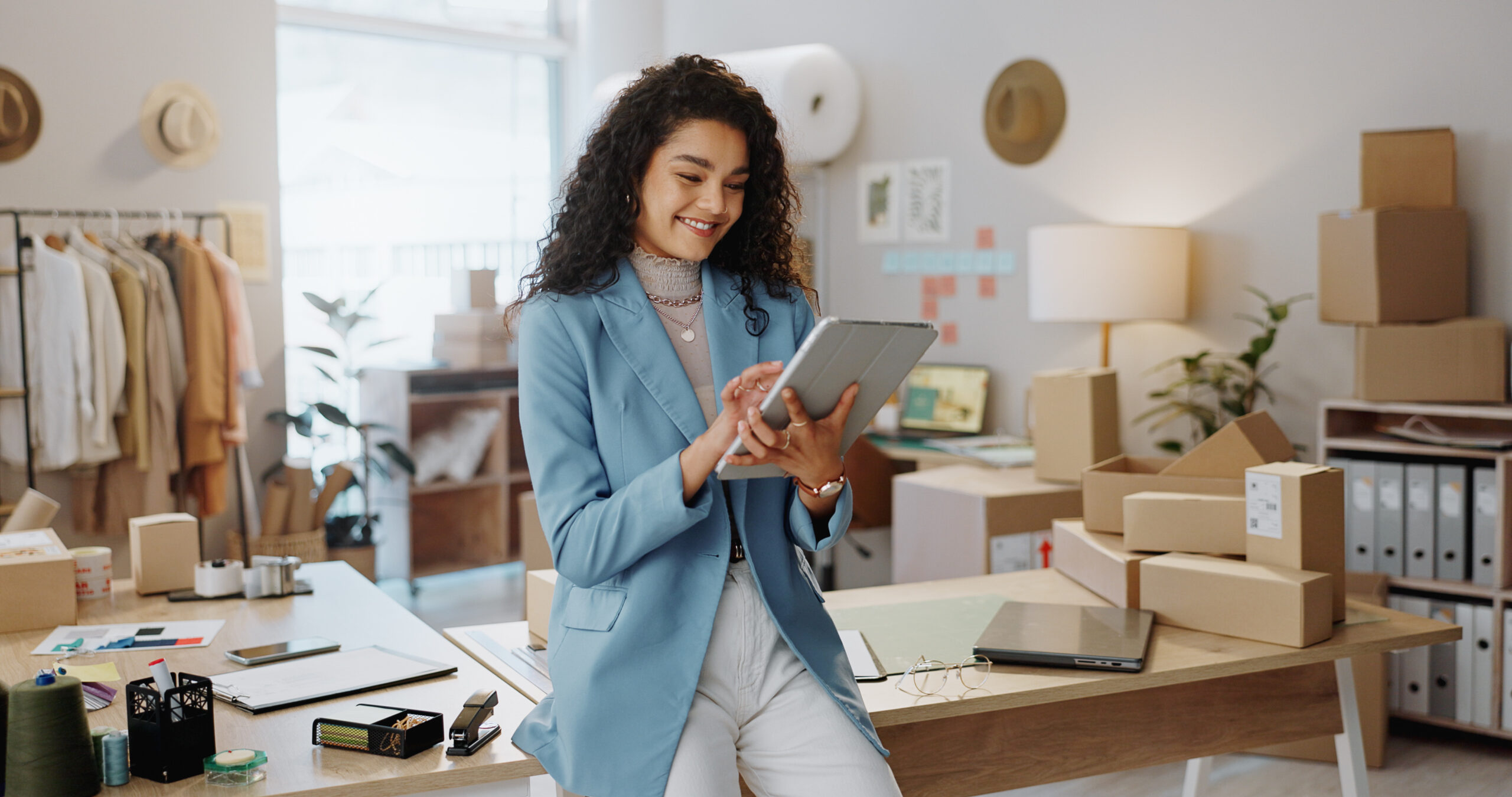 Happy woman, fashion designer and tablet in logistics or small business management at boutique.