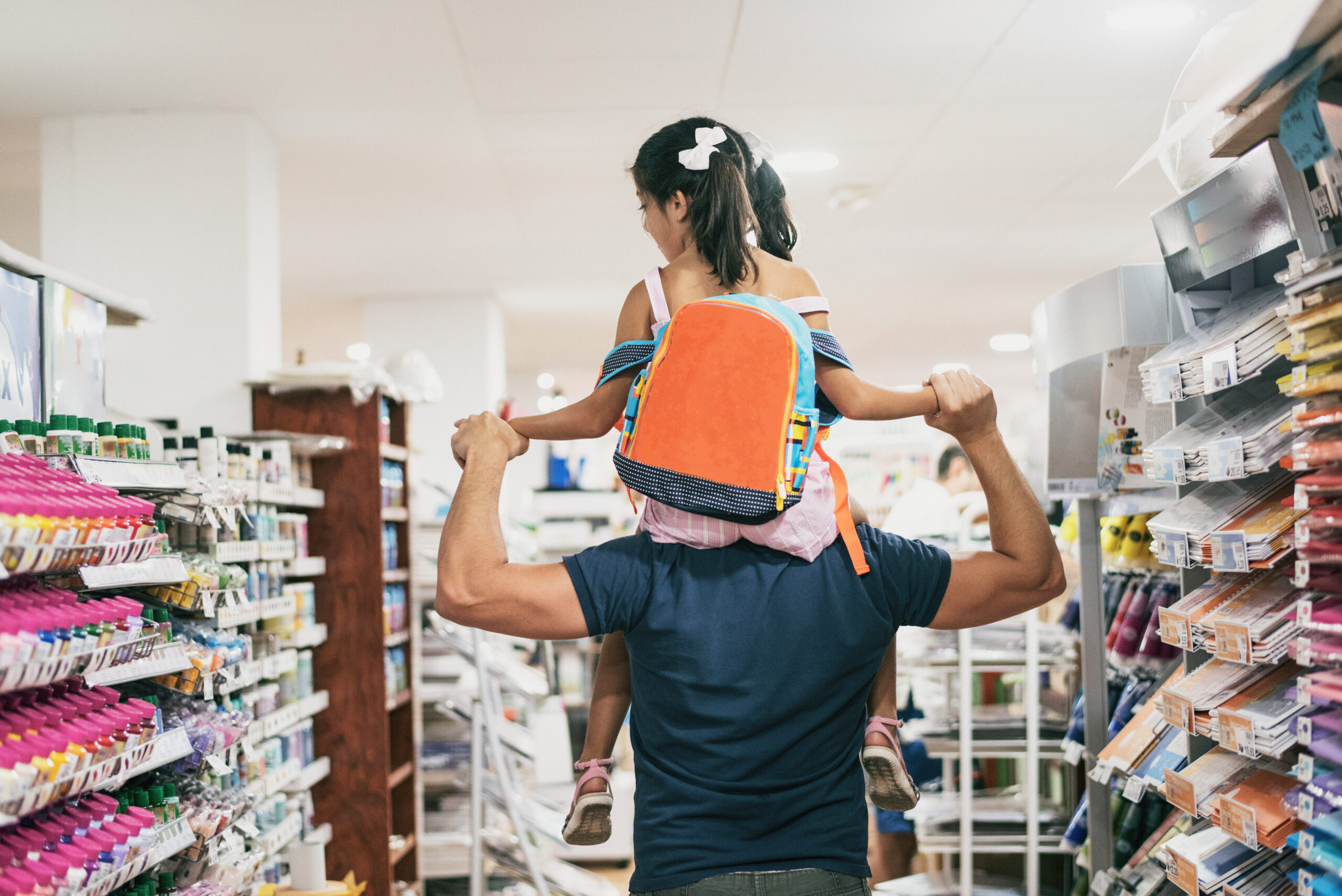 Father and daughter buying school supplies
