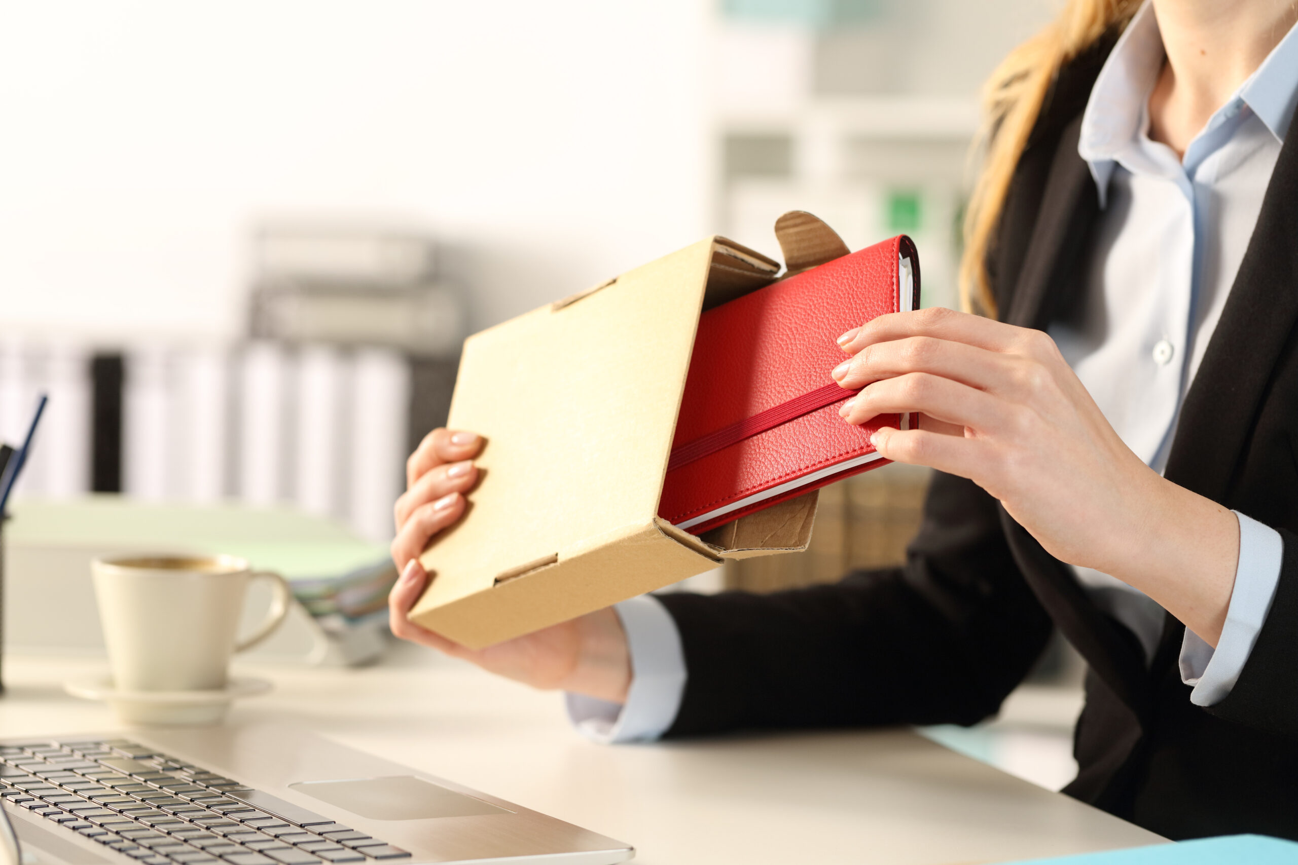 Close up of executive woman hands unboxing package delivery with agenda at the office