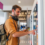 Male traveler making purchase at airport vending machine