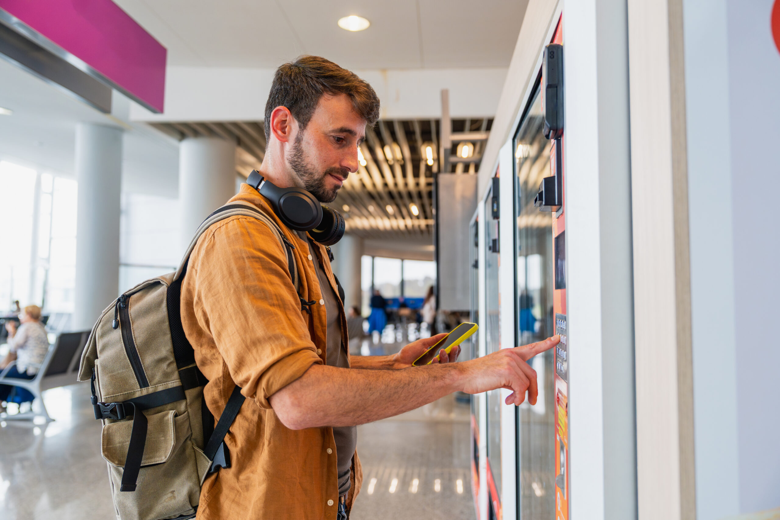 Male traveler making purchase at airport vending machine
