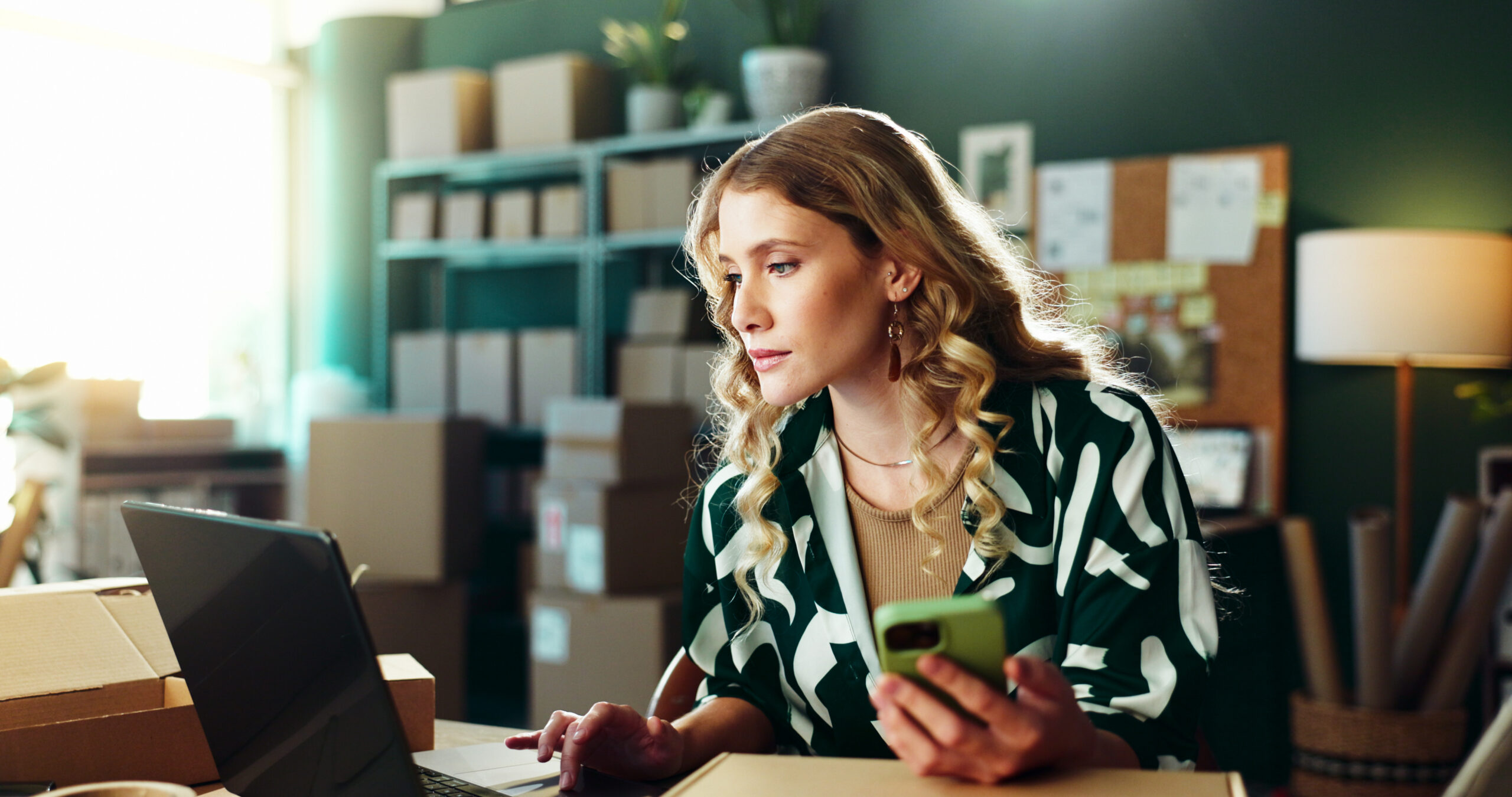 woman with laptop at small business for inventory management or compare invoice.