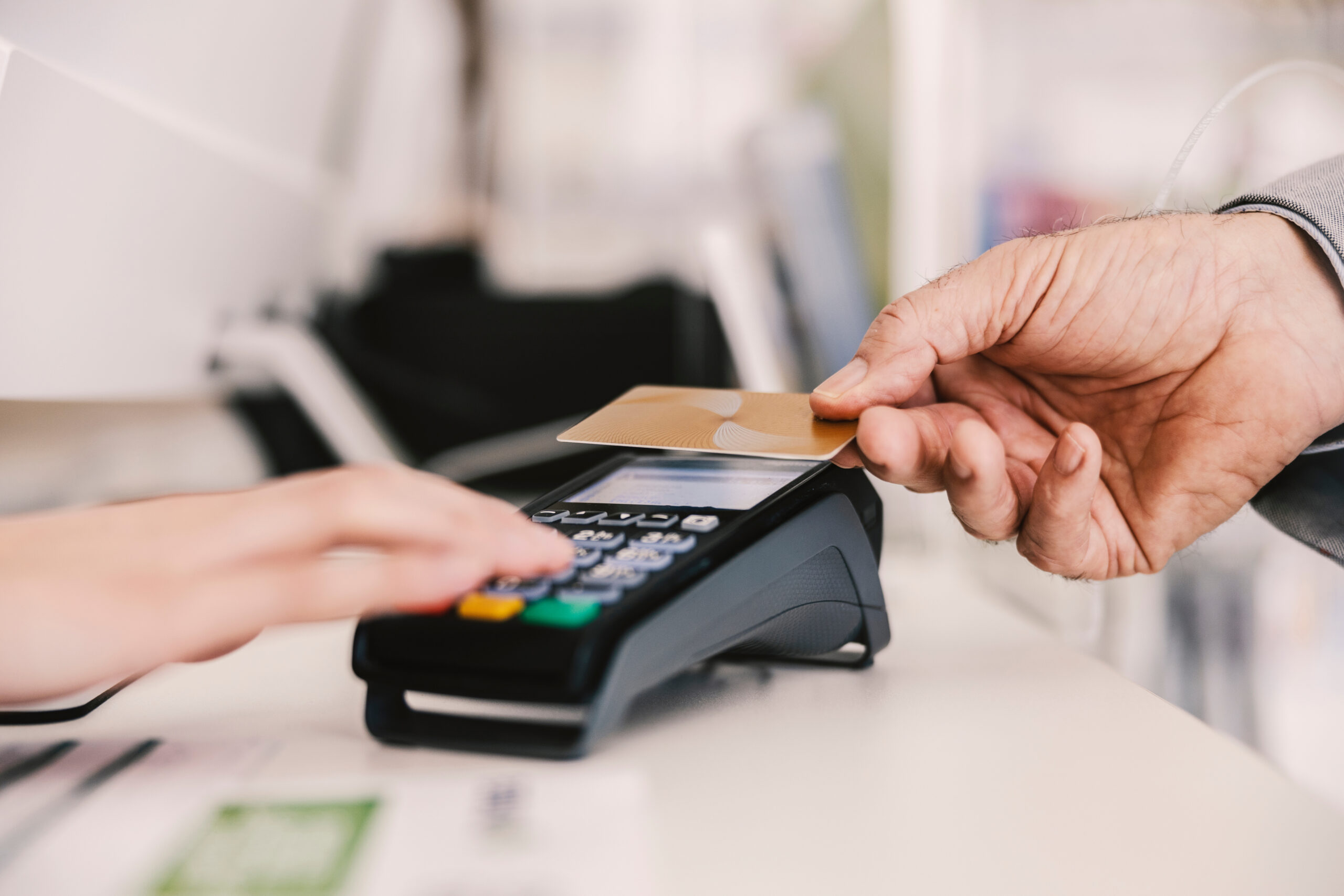 Close up of old man paying with credit card on pos terminal.